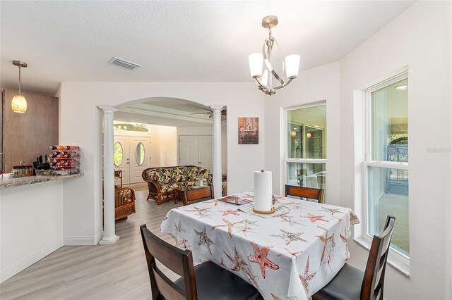 5032 N Crossgate Pt, Beverly Hills, FL 34465 - dining room with decorative columns, arched walkways, light wood-style flooring, and baseboards