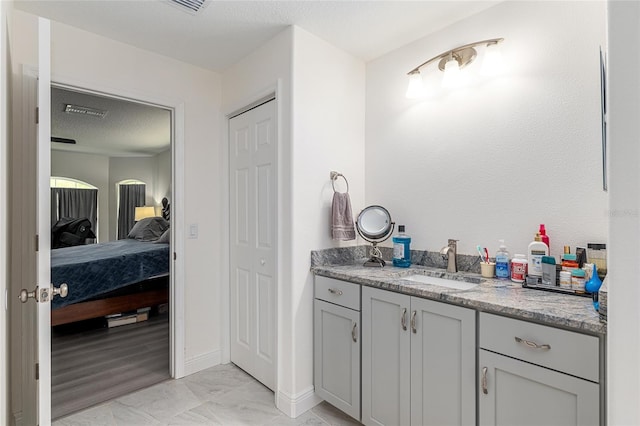 5032 N Crossgate Pt, Beverly Hills, FL 34465 - bathroom featuring ensuite bathroom, vanity, baseboards, and a textured ceiling