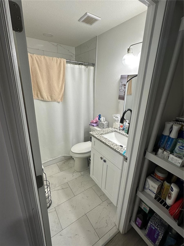 601 N Hercules Ave Unit 1008, Clearwater, FL 33765 - full bath with vanity, a textured ceiling, toilet, marble look tiles, and a shower with curtain