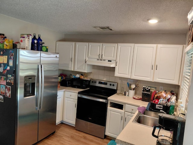 7317 Mitchell Ranch Rd, New Port Richey, FL 34655 - kitchen featuring appliances with stainless steel finishes, under cabinet range hood, white cabinetry, and a textured ceiling