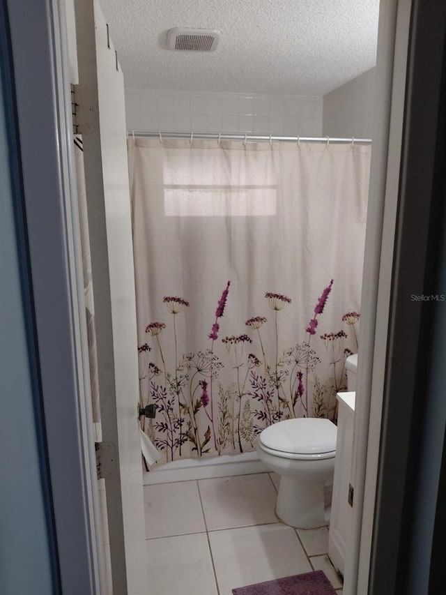 7317 Mitchell Ranch Rd, New Port Richey, FL 34655 - bathroom with a textured ceiling, toilet, vanity, curtained shower, and tile patterned flooring