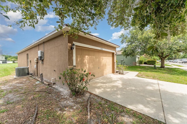6898 Glenbrook Dr, Lakeland, FL 33811 - view of side of property featuring cooling unit, stucco siding, a yard, driveway, and an attached garage