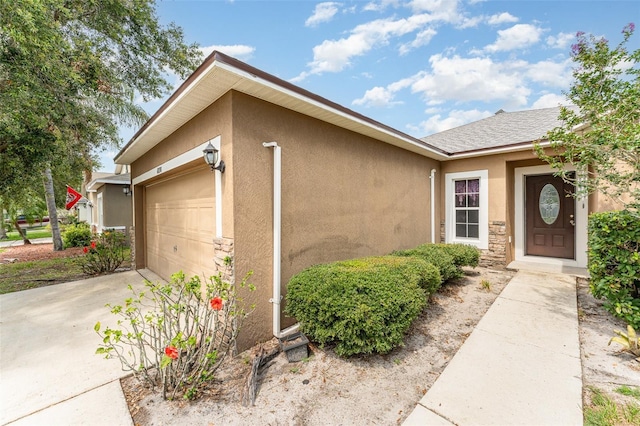 6898 Glenbrook Dr, Lakeland, FL 33811 - view of front facade featuring stucco siding, an attached garage, concrete driveway, stone siding, and roof with shingles