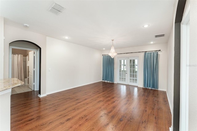 6898 Glenbrook Dr, Lakeland, FL 33811 - unfurnished room featuring recessed lighting, wood finished floors, arched walkways, baseboards, and a chandelier