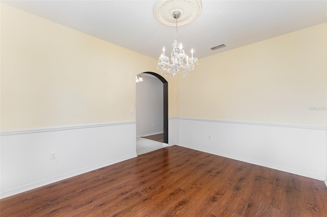 6898 Glenbrook Dr, Lakeland, FL 33811 - unfurnished room featuring arched walkways, wood finished floors, baseboards, and a chandelier