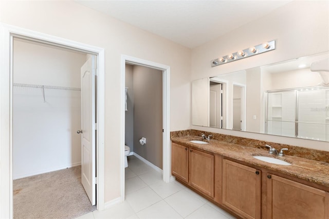 6898 Glenbrook Dr, Lakeland, FL 33811 - bathroom featuring a stall shower, double vanity, toilet, a spacious closet, and baseboards