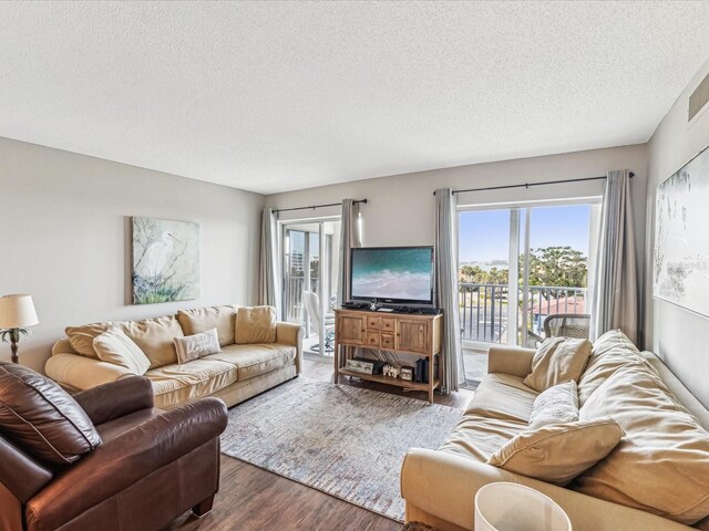 10216 Regal Dr Unit 409, Largo, FL 33774 - living area featuring a textured ceiling, wood finished floors, and plenty of natural light