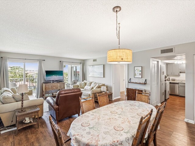 10216 Regal Dr Unit 409, Largo, FL 33774 - dining room featuring a textured ceiling, dark wood-type flooring, and healthy amount of natural light