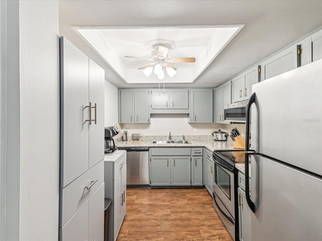 10216 Regal Dr Unit 409, Largo, FL 33774 - kitchen with appliances with stainless steel finishes, a sink, a tray ceiling, gray cabinets, and ceiling fan