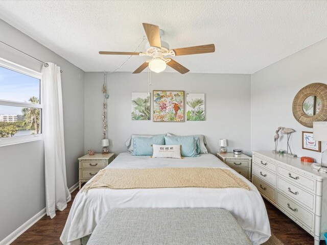 10216 Regal Dr Unit 409, Largo, FL 33774 - bedroom featuring dark wood-style flooring, a textured ceiling, ceiling fan, and baseboards