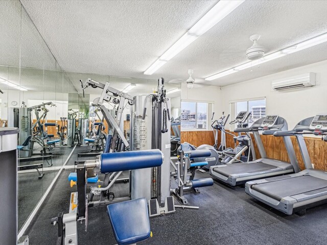 10216 Regal Dr Unit 409, Largo, FL 33774 - gym featuring a wall mounted air conditioner, a textured ceiling, and ceiling fan