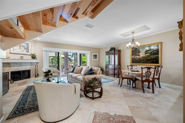 903 Pinellas Bayway S Unit 103, Tierra Verde, FL 33715 - living area featuring a chandelier, a tiled fireplace, crown molding, baseboards, and light marble finish floors