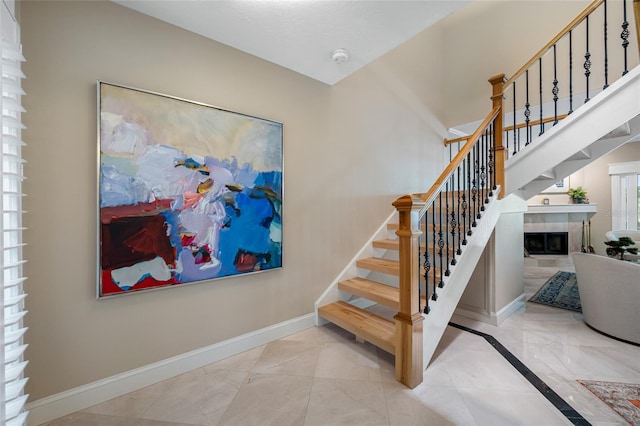 903 Pinellas Bayway S Unit 103, Tierra Verde, FL 33715 - staircase with marble tiled flooring, baseboards, and a fireplace
