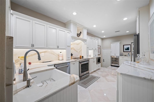 903 Pinellas Bayway S Unit 103, Tierra Verde, FL 33715 - kitchen with beverage cooler, appliances with stainless steel finishes, a sink, recessed lighting, and white cabinets