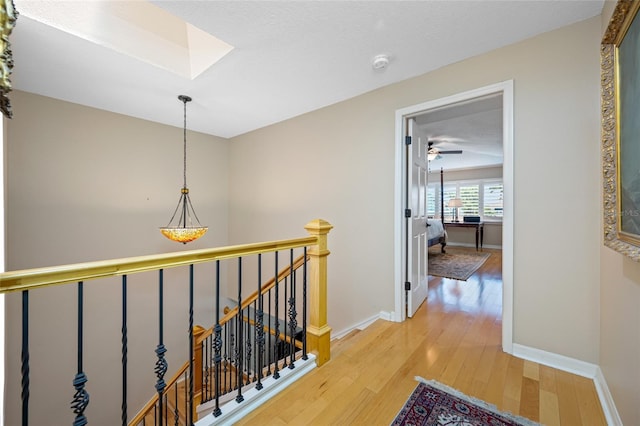 903 Pinellas Bayway S Unit 103, Tierra Verde, FL 33715 - hall with an upstairs landing, light wood-type flooring, baseboards, and a skylight