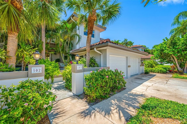 903 Pinellas Bayway S Unit 103, Tierra Verde, FL 33715 - view of property exterior with stucco siding, driveway, a tiled roof, and an attached garage
