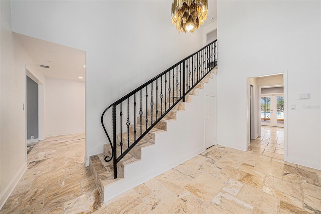 2309 Cypress Walk Way, Ruskin, FL 33570 - stairs featuring a towering ceiling, a chandelier, stone tile flooring, baseboards, and french doors