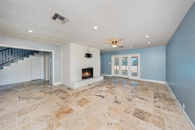 2309 Cypress Walk Way, Ruskin, FL 33570 - unfurnished living room with stone tile floors, stairway, a brick fireplace, ceiling fan, and a textured ceiling