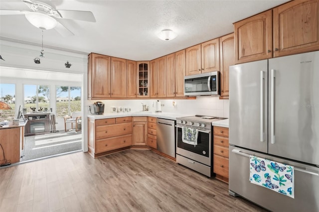 708 Rutgers Pl, Sun City Center, FL 33573 - kitchen featuring appliances with stainless steel finishes, light wood-style flooring, light countertops, and a ceiling fan
