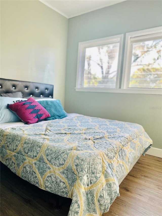 5654 12th St, Zephyrhills, FL 33542 - bedroom featuring wood finished floors, crown molding, and baseboards