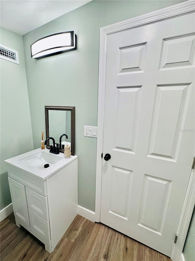 5654 12th St, Zephyrhills, FL 33542 - bathroom featuring vanity, baseboards, and wood finished floors