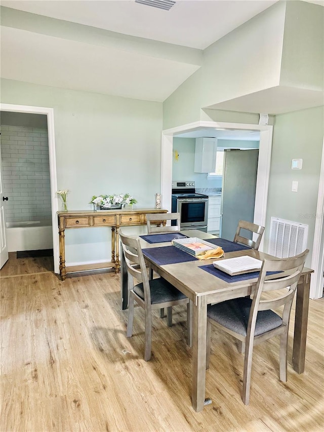 5654 12th St, Zephyrhills, FL 33542 - dining area featuring light wood-style floors and vaulted ceiling