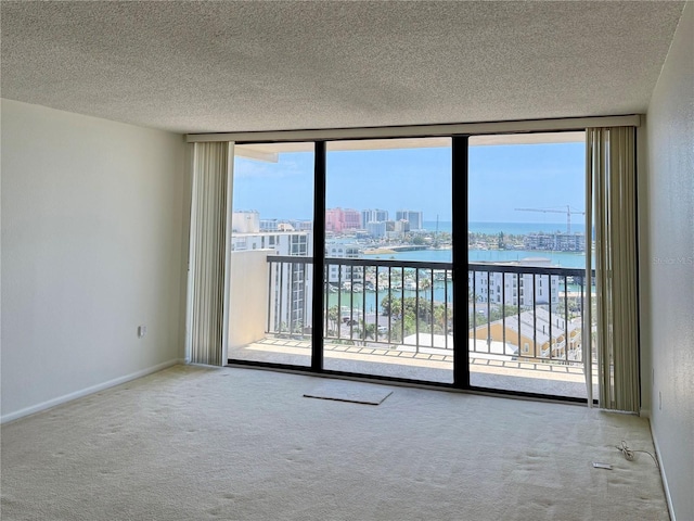 400 Island Way Unit 1402, Clearwater Beach, FL 33767 - spare room with a water view, a wall of windows, carpet, a textured ceiling, and a view of city