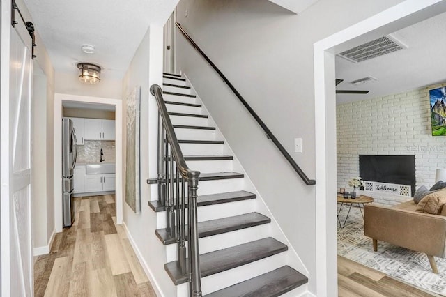 7208 N Ola Ave, Tampa, FL 33604 - staircase featuring wood finished floors and a brick fireplace