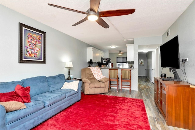 11201 122nd Ave Unit 167, Largo, FL 33778 - living room featuring ceiling fan, light wood finished floors, and a textured ceiling
