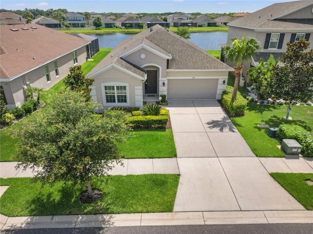 17668 Bright Wheat Dr, Lithia, FL 33547 - view of front of home featuring stucco siding, a garage, a residential view, driveway, and a water view
