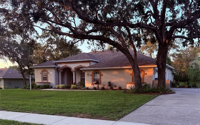 13133 Roseanna Dr, Spring Hill, FL 34609 - view of front of property featuring stucco siding, a front lawn, roof with shingles, and concrete driveway