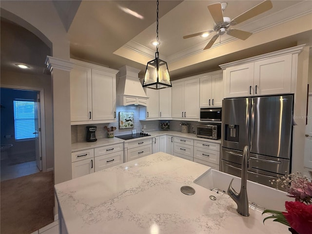 13133 Roseanna Dr, Spring Hill, FL 34609 - kitchen with appliances with stainless steel finishes, custom exhaust hood, ornamental molding, a ceiling fan, and a raised ceiling