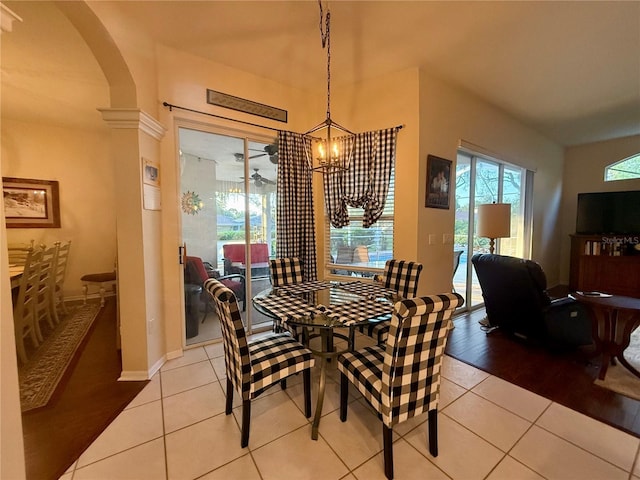 13133 Roseanna Dr, Spring Hill, FL 34609 - dining space with arched walkways, a chandelier, light tile patterned floors, and baseboards