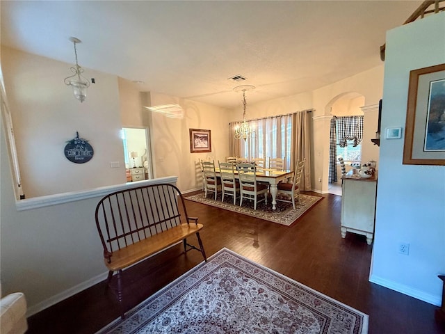 13133 Roseanna Dr, Spring Hill, FL 34609 - dining area with wood finished floors, arched walkways, a chandelier, and baseboards