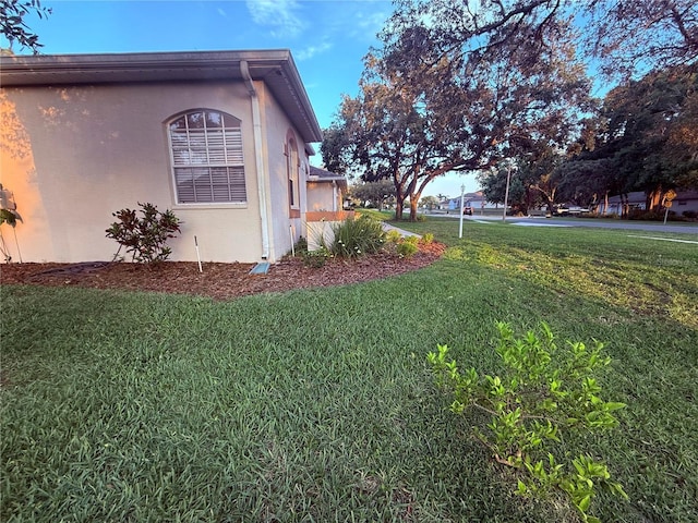 13133 Roseanna Dr, Spring Hill, FL 34609 - view of side of home with stucco siding and a lawn