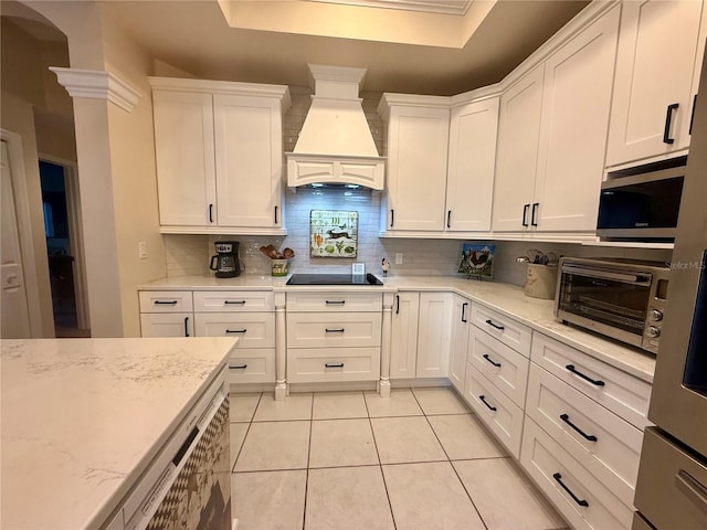 13133 Roseanna Dr, Spring Hill, FL 34609 - kitchen with custom range hood, backsplash, a raised ceiling, stainless steel microwave, and light tile patterned flooring