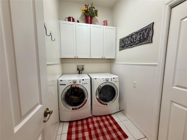 13133 Roseanna Dr, Spring Hill, FL 34609 - washroom featuring cabinet space, washer and clothes dryer, light tile patterned floors, and wainscoting