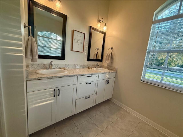 13133 Roseanna Dr, Spring Hill, FL 34609 - bathroom with double vanity, tile patterned floors, and baseboards