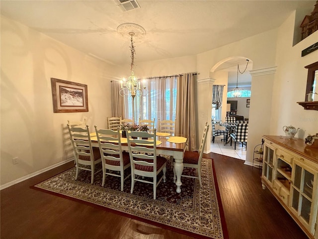13133 Roseanna Dr, Spring Hill, FL 34609 - dining space with arched walkways, a chandelier, wood finished floors, and baseboards