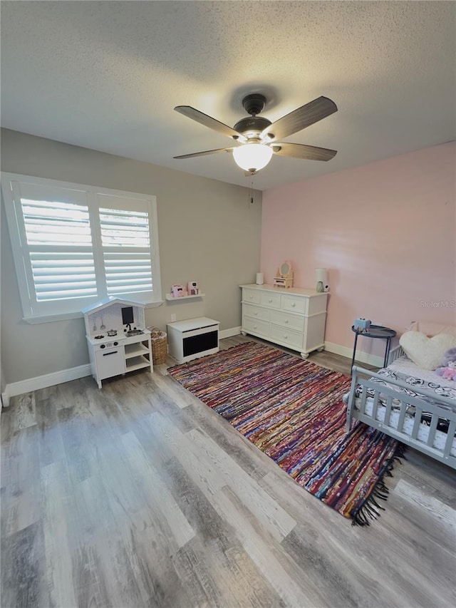 30 Tads Trl, Oldsmar, FL 34677 - bedroom featuring wood finished floors, a textured ceiling, baseboards, and a ceiling fan