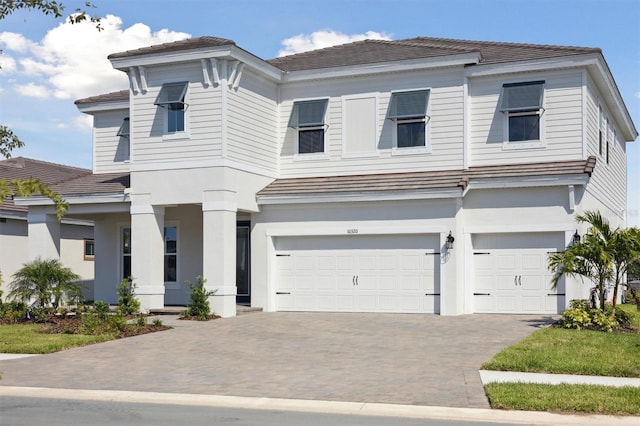 10320 Longmeadow Ave, Parrish, FL 34219 - view of front facade with an attached garage, decorative driveway, and stucco siding