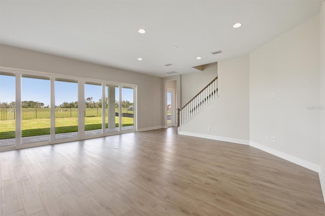 10320 Longmeadow Ave, Parrish, FL 34219 - unfurnished living room featuring baseboards, wood finished floors, recessed lighting, and stairs