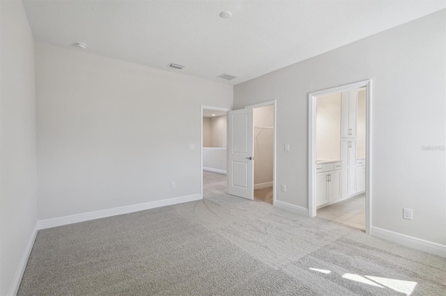 10320 Longmeadow Ave, Parrish, FL 34219 - unfurnished bedroom with a walk in closet, light colored carpet, and baseboards