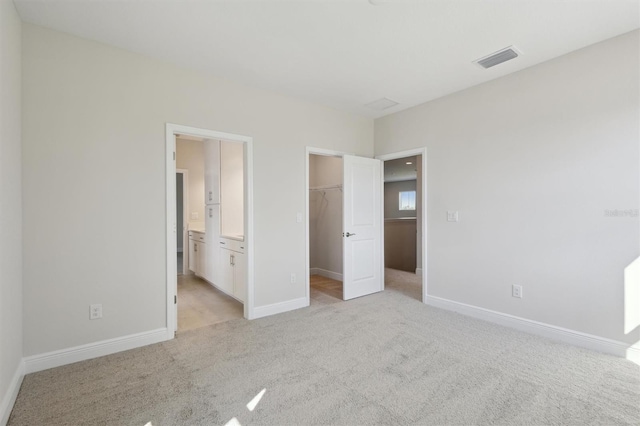 10320 Longmeadow Ave, Parrish, FL 34219 - unfurnished bedroom with light colored carpet, a spacious closet, baseboards, and a closet