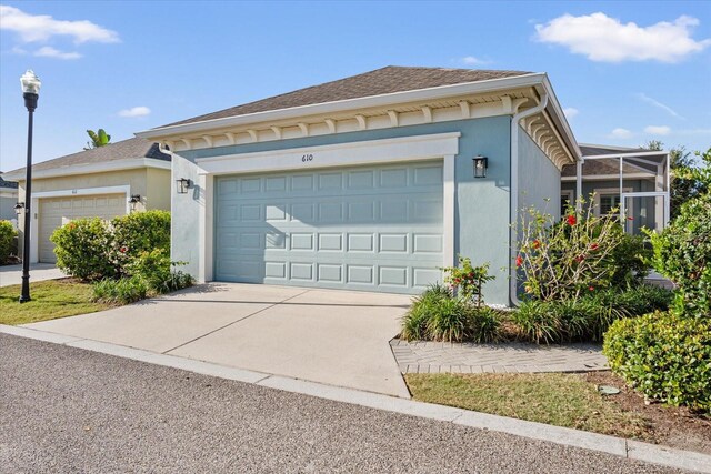 610 Winterside Dr, Apollo Beach, FL 33572 - view of front facade with stucco siding, an attached garage, and driveway