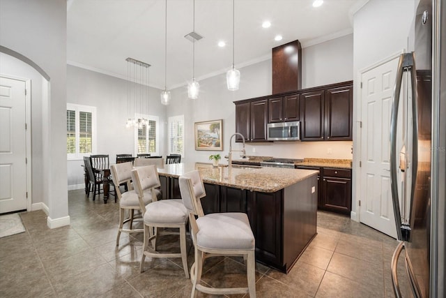 610 Winterside Dr, Apollo Beach, FL 33572 - kitchen with appliances with stainless steel finishes, a sink, crown molding, a center island with sink, and dark brown cabinets