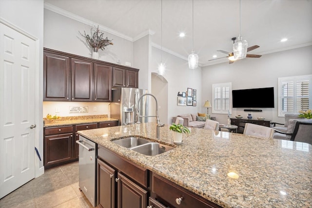 610 Winterside Dr, Apollo Beach, FL 33572 - kitchen featuring a sink, stainless steel appliances, arched walkways, ceiling fan, and light stone counters