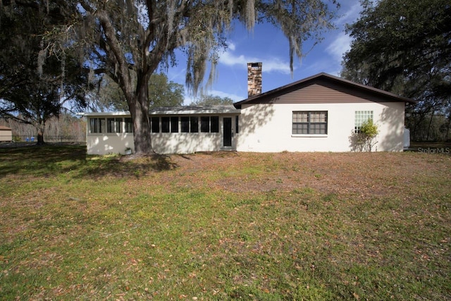 3705 Bruton, Plant City, FL 33565 - rear view of house with a chimney, a sunroom, and a yard