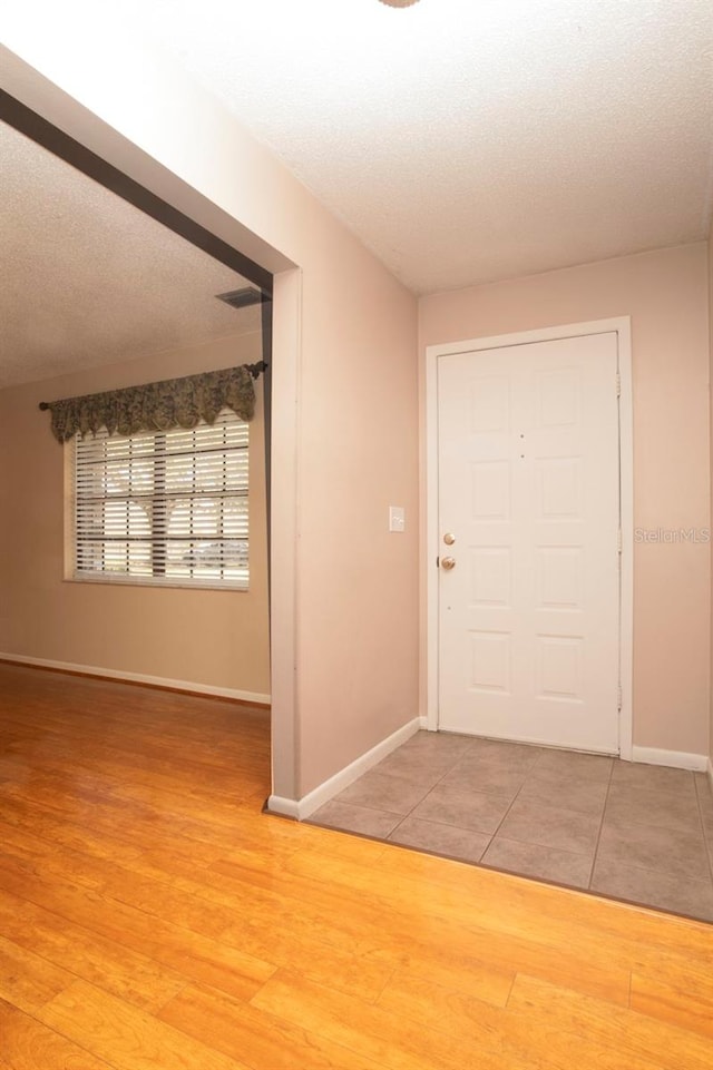 3705 Bruton, Plant City, FL 33565 - foyer featuring baseboards, a textured ceiling, and light wood-style floors