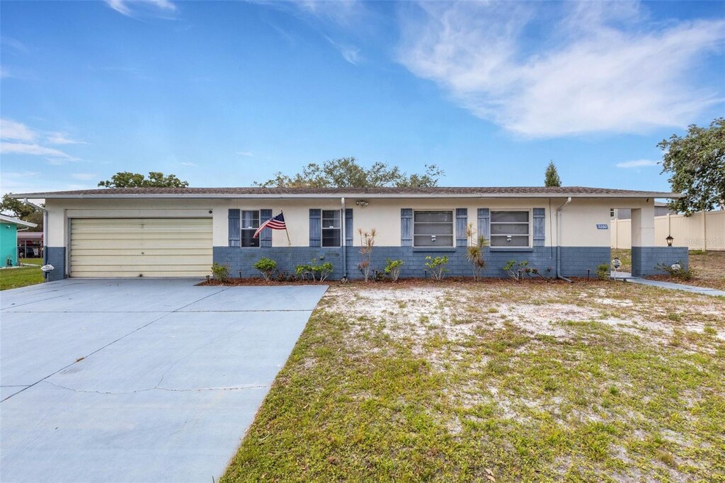 5250 Brody Blvd, Wimauma, FL 33598 - ranch-style home with stucco siding, concrete driveway, and an attached garage